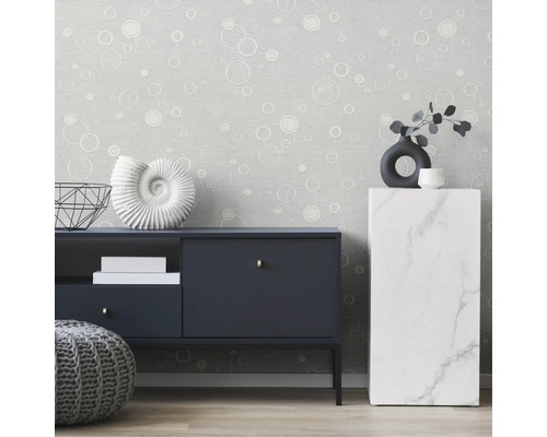 Salon avec papier peint gris à motif circulaire, buffet et décoration