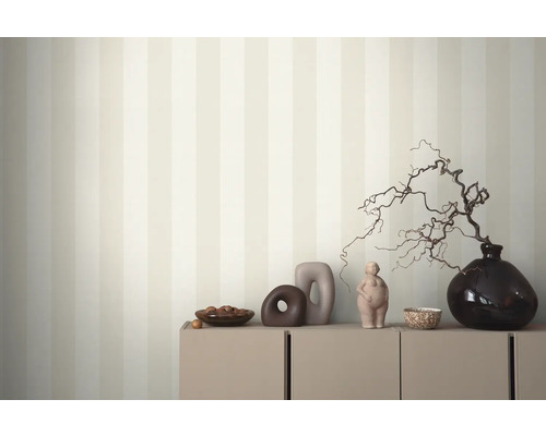 Intérieur décoratif avec papier peint rayé, armoire et divers objets décoratifs.