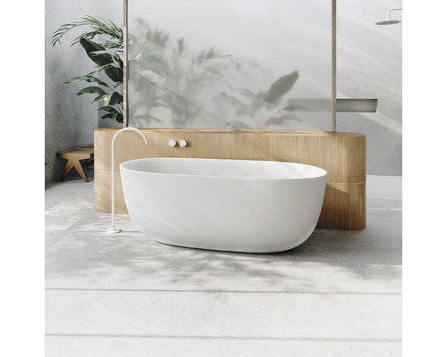 Freistehende Badewanne in einem hellen Badezimmer mit Pflanzen und Holzelementen