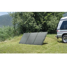 Tragbares Solarmodul auf einer Wiese neben einem Wohnmobil