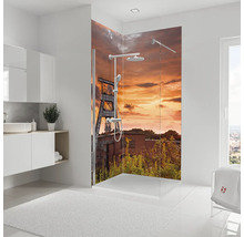 Salle de bain avec cabine de douche et motif d''une installation industrielle au coucher du soleil