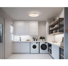 Buanderie lumineuse avec machines à laver, lavabo et étagères