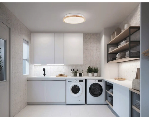 Buanderie lumineuse avec machines à laver, lavabo et étagères