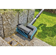 Brosse Gardena pour le nettoyage des joints en utilisation sur un mur de pierre