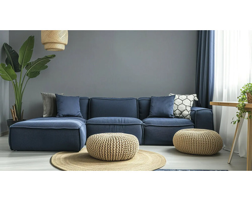 Wohnzimmer mit modularem Sofa, Poufs und Zimmerpflanze für ein gemütliches Ambiente