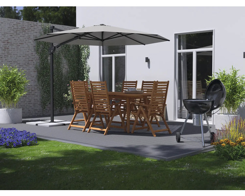 Terrassenszene mit Holzgartengarnitur, Sonnenschirm und Grill