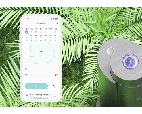 Smartphone avec l''application IrriSense ouverte à côté d''un système d''irrigation dans le jardin.