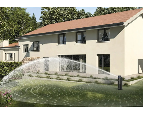 Arroseur escamotable arrosant la pelouse devant une maison