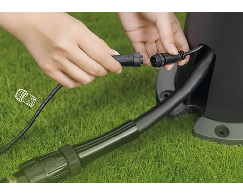 Raccordement d''un câble de projecteur de jardin avec fiche sur une pelouse