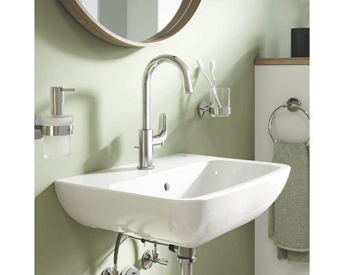 Lavabo avec robinet, distributeur de savon, gobelet à brosses à dents et anneau de serviette dans la salle de bains