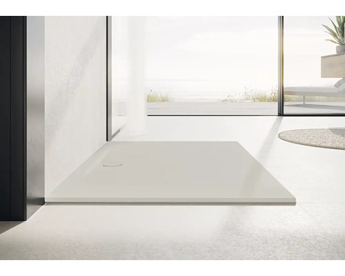 Receveur de douche plain-pied dans une salle de bains lumineuse.