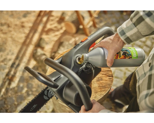 Personne remplit une tronçonneuse avec de l'huile