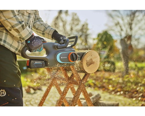 Tronçonneuse à batterie en action coupant une bûche sur un chevalet