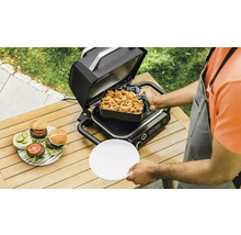 Scène avec un gril électrique ouvert, des hamburgers préparés et des frites sur une table de jardin.