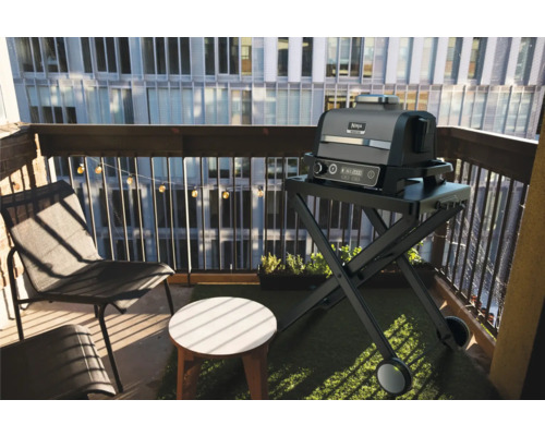 Balkonszene mit Ninja Foodi Grill auf einem Rollwagen, Stuhl und Beistelltisch