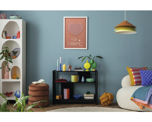 Salon avec étagère blanche, étagère noire, tabouret et éléments décoratifs au mur