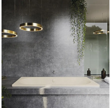 Salle de bain avec baignoire rectangulaire, carrelage gris et suspensions annulaires.