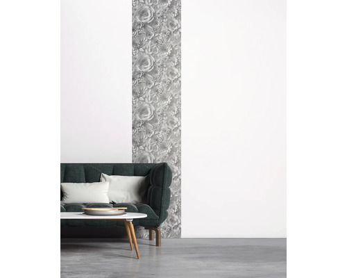 Wohnzimmer mit dunkelgrünem Sofa, Couchtisch und floral gemusterter Tapete