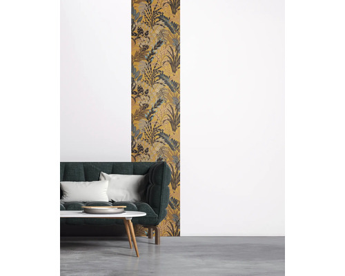 Einrichtungsbeispiel mit einer gemusterten Tapete mit Pflanzenmotiven hinter einem Sofa.