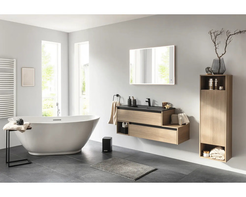 Salle de bain lumineuse avec baignoire, lavabo, miroir et armoire pour une ambiance organisée.