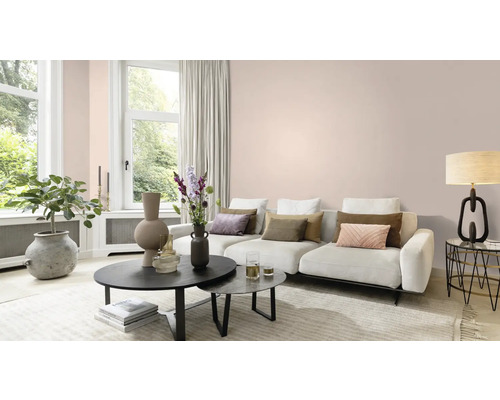 Heller Wohnraum mit Sofa, Couchtischen und Dekoration