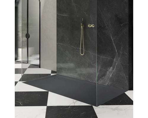 Espace douche avec receveur de douche, robinetterie de douche et paroi de douche devant un mur en marbre noir