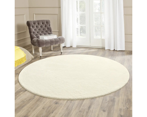 Runder Teppich im Wohnzimmer mit Sessel und Tageslicht