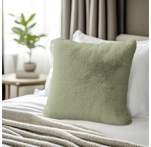 Coussin décoratif en fausse fourrure sur un lit