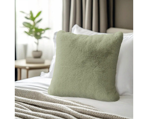 Coussin décoratif en fausse fourrure sur un lit