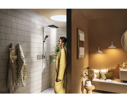 Badezimmer mit Dusche, Sitzbereich und einer Frau unter der Dusche.