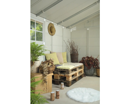 Gemütliche Sitzecke in einem Gartenhaus mit Palettenmöbeln, Kissen und Pflanzen