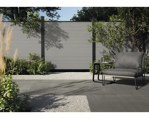 Scène de jardin moderne avec éléments de clôture, allée de gravier, coin salon et plantes