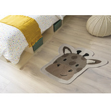 Zimmerszene mit Bett, Sitzkissen und einem Teppich in Form eines Giraffenkopfes.