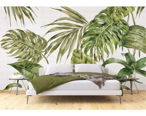 Chambre avec un ensemble de literie blanc devant un papier peint à feuilles tropicales