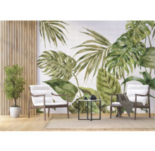 Intérieur décoratif avec une fresque murale de feuilles tropicales, des fauteuils et une table d'appoint.