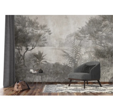 Scène avec un fauteuil, une table avec des livres et un sac devant un revêtement mural à motif jungle.
