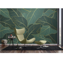 Salon avec papier peint à motif de feuilles en vert et or, fauteuil avec repose-pieds, tapis et table d'appoint avec décoration