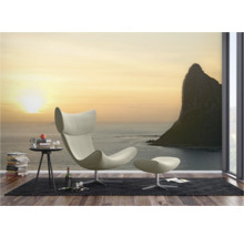 Wohnzimmer mit Sessel, Fusshocker und Fototapete mit Meeresmotiv