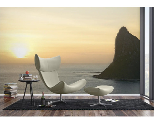 Wohnzimmer mit Sessel, Fusshocker und Fototapete mit Meeresmotiv
