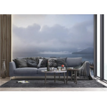 Wohnzimmer mit Sofa, Couchtischen und Fototapete mit Seemotiv.