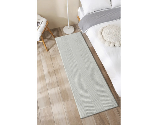 Schlafzimmer mit Bett und grauem Teppichläufer mit Fischgrätenmuster