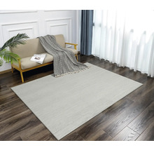 Wohnzimmer mit Sofa und Teppich mit Fischgrätenmuster auf Holzboden