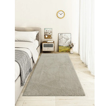 Heller Teppich im Schlafzimmer neben einem Bett und Nachttisch.