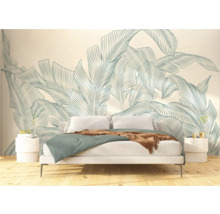 Chambre avec lit devant un papier peint au motif de feuilles botaniques