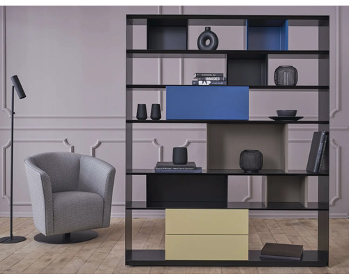 Wohnzimmer mit Bücherregal, Sessel und Stehlampe