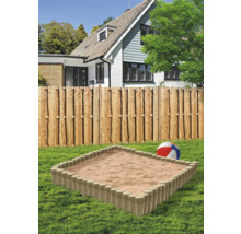 Sandkasten mit Holzumrandung im Garten vor einem Haus
