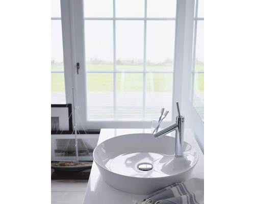 Salle de bain lumineuse avec lavabo à poser, robinet et fenêtre