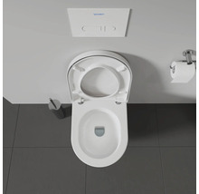 Photo de toilettes avec abattant ouvert, chasse d'eau, papier toilette et brosse de toilette.