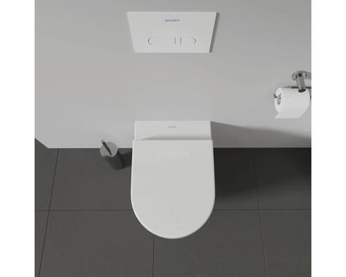 Vue de dessus de toilettes avec plaque de commande, support de papier toilette et brosse de toilette