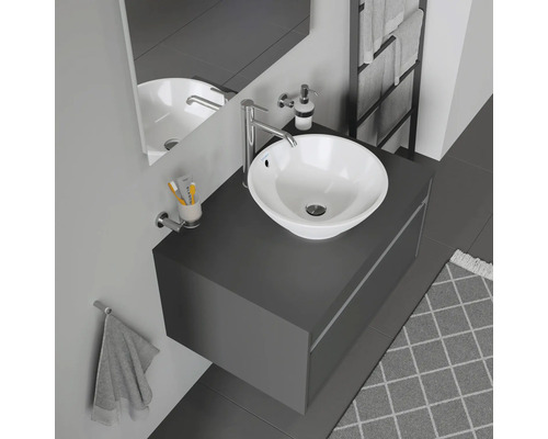 Salle de bain moderne avec vasque à poser, robinetterie, miroir et porte-serviettes.